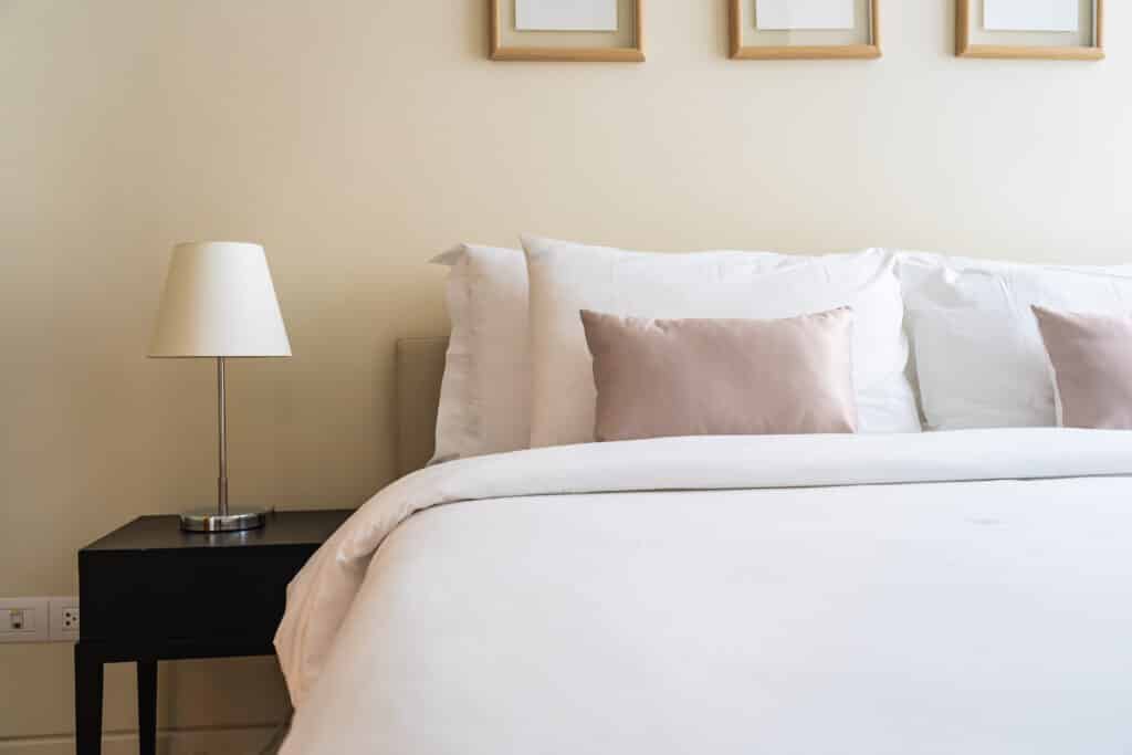 cleanly made bed in riverside ca home potentially dealing with carpet beetles or bed bugs