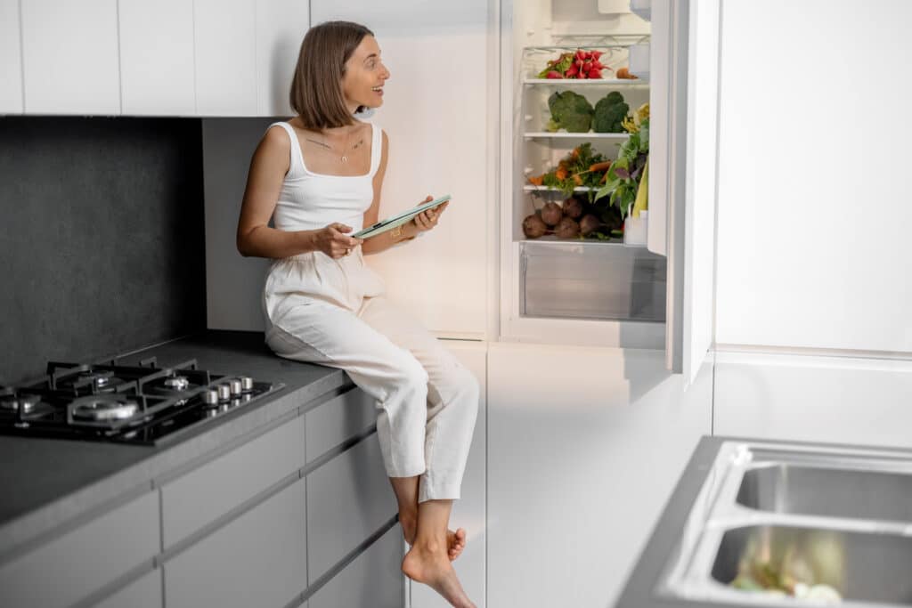 woman homeowner in riverside ca sitting on counter wondering what to do with refrigerator before tent fumigation