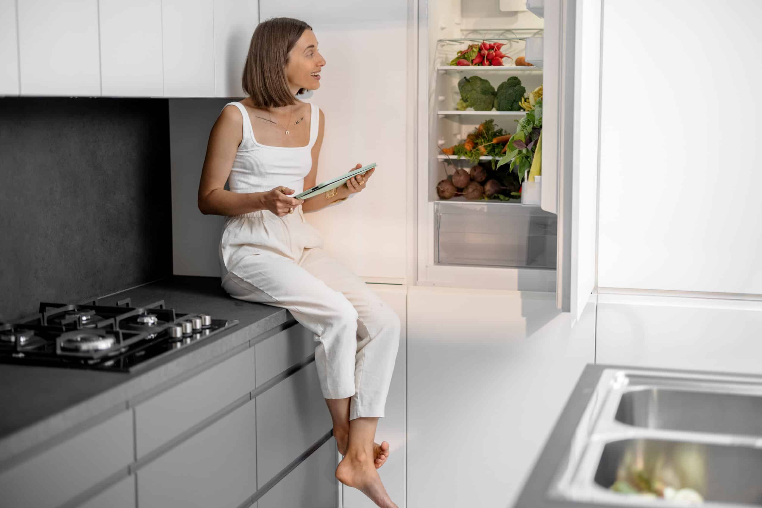 woman homeowner in riverside ca sitting on counter wondering what to do with refrigerator before tent fumigation