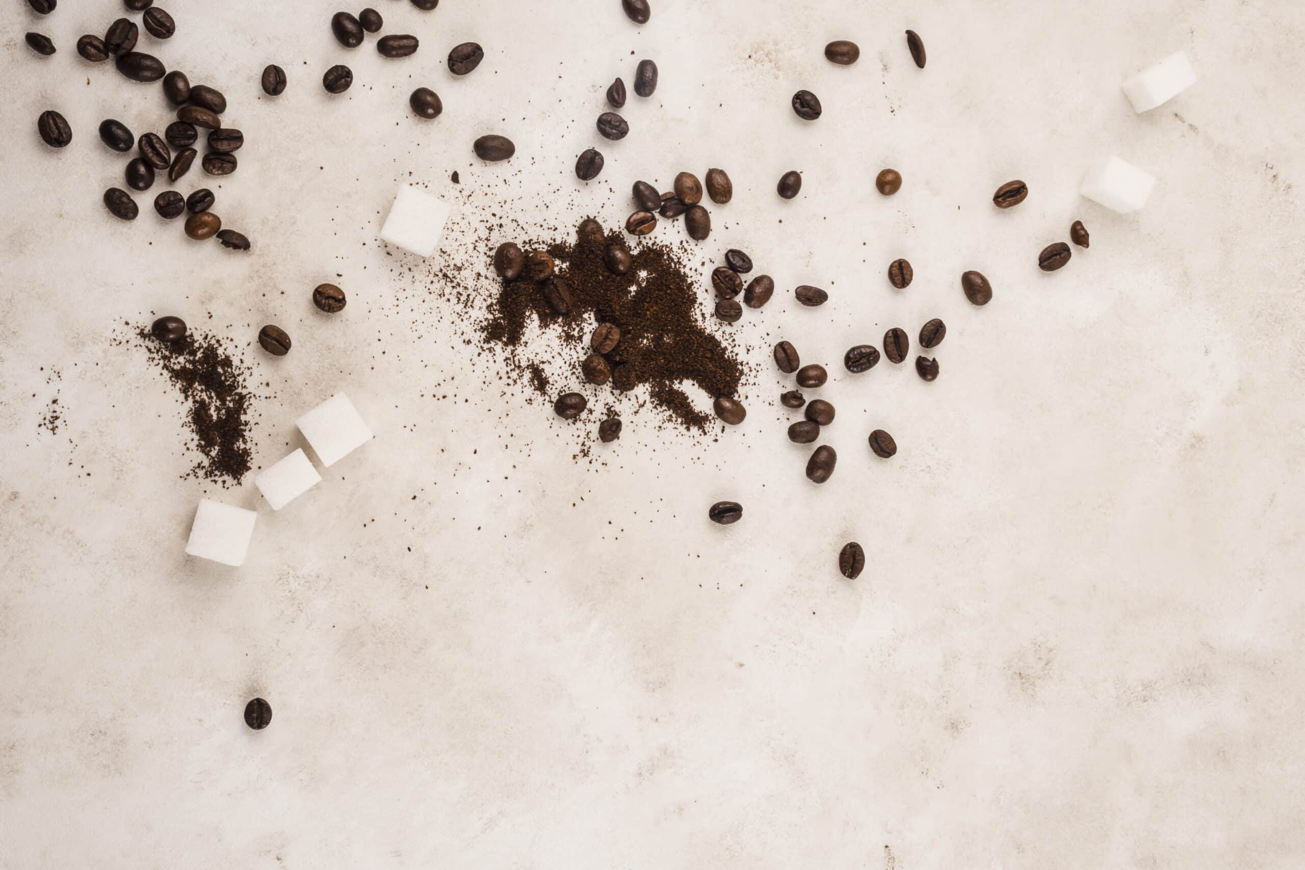 overhead shot of coffee beans, coffee grounds, and sugar cubes on table in riverside ca wondering if its termite droppings