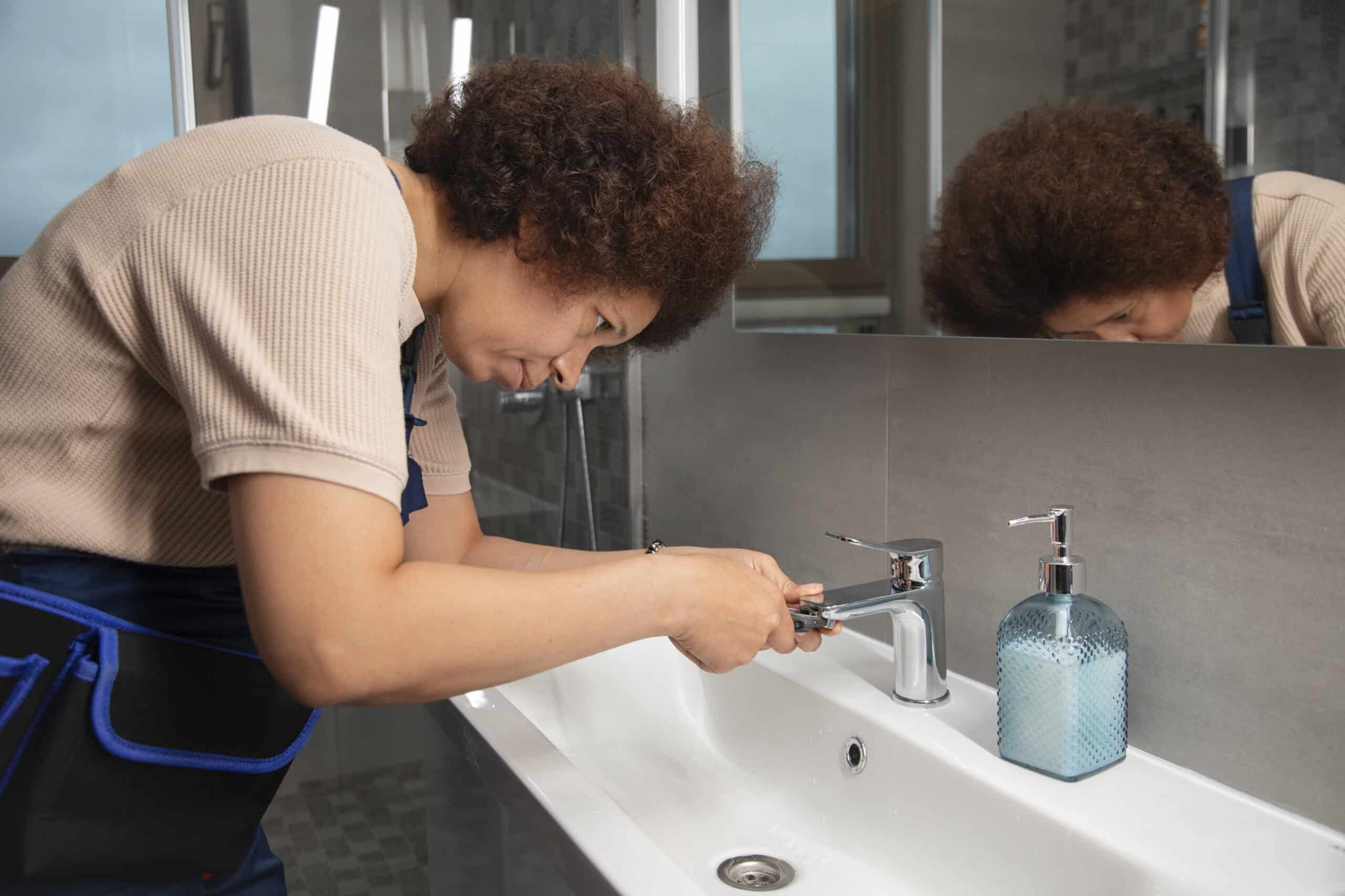 woman homeowner in riverside ca looking at tiny ants in the bathroom sink